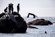 Bailey Pearce backflips off a rock at Tauranga Bay, Westport, West Coast, New Zealand.