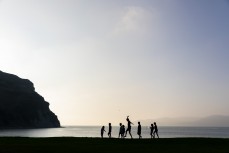 Kids play on a beach at dusk on the Mahia Peninsula near Gisborne, Eastland, New Zealand.