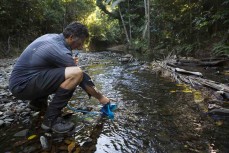 Dallas Hewett refills his water bladder during a three-day mountain biking and hiking trek into Cedar Bay National Park in North Queensland, Australia. 