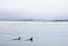 Surfer girls Rewa, 13 and Bella, 12, head out for a surf during a small swell on the north coast, Dunedin, New Zealand.Credit: www.boxoflight.com/Derek Morrison