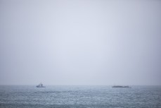 Rain and offshore conditions as a boat tows a sand barge on the North Coast, Dunedin, New Zealand.Credit: www.boxoflight.com/Derek Morrison