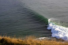 Craig Higgins racing down the line during a clean winter swell at a fickle break on the North Coast, Dunedin, New Zealand.Credit: www.boxoflight.com/Derek Morrison