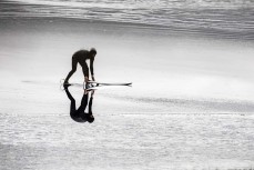 A surfer heads out during a fun swell on the north coast, Dunedin, New Zealand.Credit: www.boxoflight.com/Derek Morrison