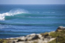 Surfers ride clean offshore waves in the Catlins, Southland, New Zealand. 