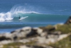 Surfers ride clean offshore waves in the Catlins, Southland, New Zealand. 