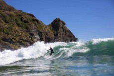 A surfer negotiates the steps at the Bar at Piha, Auckland, New Zealand.