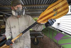 Doug Astill repairs a paddle ahead of the Pearl of the North waka ama race held near Te Tii, Northland, New Zealand.