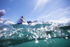 A waka ama team slices through water at Taronui Bay during the Pearl of the North waka ama race held near Te Tii, Northland, New Zealand.