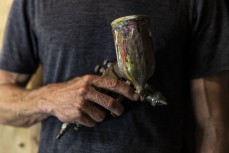 Jaimie Scott with his trusty spray gun in his shaping bay at Tribal Surfboards, near Whananaki Tutukaka Coast, Northland, New Zealand.