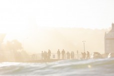Crowds gather to watch playful waves during a late autumn swell at St Clair, Dunedin, New Zealand.