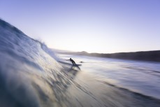 A surfer draws off the bottom in clean waves during a winter session at Blackhead, Dunedin, New Zealand.