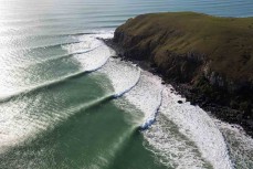 Winter swell wraps into a point break on the North Coast, Dunedin, New Zealand.