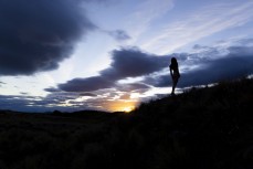 Girl silhouetted by dramatic skies near Lake Tekapo, Canterbury, New Zealand.Credit: www.boxoflight.com/Derek Morrison