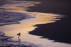 A surfer leaves the water at sunset at Blackhead, Dunedin, New Zealand.Photo: Derek Morrison