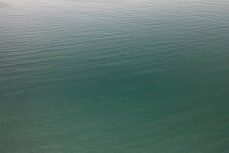 A kayaker on the coastline near Warrington, Dunedin, New Zealand.
