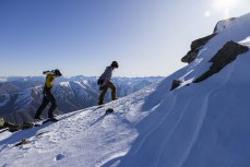 Alex Minhinnick and Patrick Bezett hike the summit at Cardrona ski field, Cardrona Valley, Wanaka, New Zealand.