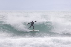 A surfer during a northeast swell at a remote pointbreak near Dunedin, New Zealand.Credit: Derek Morrison