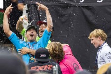 Elliot Paerata-Reid, Billy Stairmand and Kalani Louis celebrate the win by Dune Kennings at the 2023 New Zealand Surfing Championships held at Piha, Auckland, New Zealand. Photo: Derek Morrison