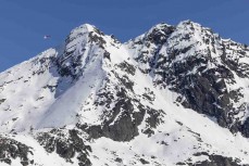 A helicopter flies over the peak during early spring at The Remarkables ski field, Queenstown, Central Otago, New Zealand.