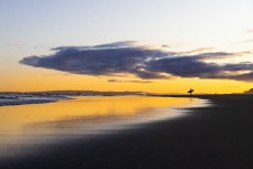 A surfer heads for home on dusk at Smaills Beach, Dunedin, New Zealand.