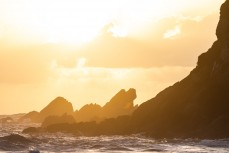 Sunset over rocky outcrops at Tauranga Bay, Westport, West Coast, New Zealand.