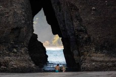 Swimmers make their way through the Keyhole at Piha, Auckland, New Zealand.