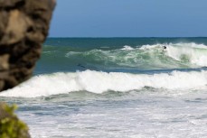 A surfer drops into a set wave as a new swell wraps into south-facing beaches in Wellington, New Zealand.