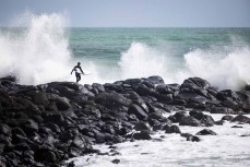 Billy Stairmand heads out during a spring swell at Manu Bay, Raglan, Waikato, New Zealand.