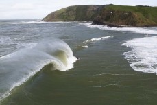 Sam Blackman pulls out the front on a giant wave at a remote reef break in the Catlins, New Zealand. Photo: Derek Morrison