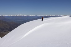 Tony James of the Sidehit Podcast hunts for fresh lines over ther back of Cardrona ski field, Cardrona Valley, Wanaka, New Zealand.