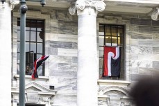 Parliament supporters fly tino rangatiratanga flags out the windows of parliament during the hīkoi mō te tiriti, Wellington, New Zealand. November 19, 2024.Photo: Derek Morrison