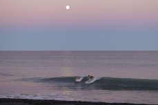 Kalani Summerton and Thomas Owen enjoy a boardies surf under the full moon at a surf break near Kaikoura, New Zealand. Photo: Derek Morrison