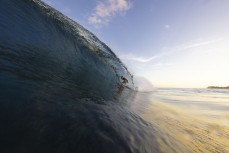 Frank Roberts gets barreled on dusk at a remote reefbreak in the Mentawai Islands, Sumatra, Indonesia.