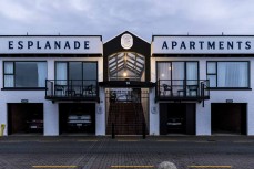 Winter sunrise reflects on windows of Esplanade Apartments at St Clair, Dunedin, New Zealand.