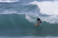 A surfer negotiates a section during a southerly swell at a beach break on the Otago Peninsula, Dunedin, New Zealand.