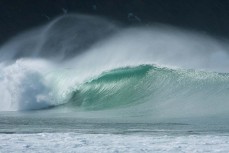 Surfers make the most of the waves at Purakanui Bay in the Catlins, New Zealand. 