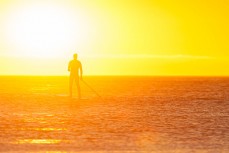 Stand up paddleboarder at St Clair Beach, Dunedin, New Zealand. 