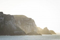 Morning glow on cliffs at a remote beach break in the Catlins, New Zealand. Photo: Derek Morrison