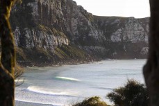 Morning glow as peaks wander in at a remote beach break in the Catlins, New Zealand. Photo: Derek Morrison