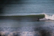 A surfer makes the most of a surprise swell on dusk at Belt Road, New Plymouth, Taranaki, New Zealand.