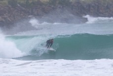 Moss Thompson gets barelled during a swell on the north coast of Dunedin, New Zealand.