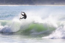 Noah Camburn into the air during a swell on the north coast of Dunedin, New Zealand.