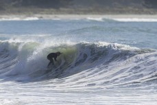 Keo Morrison tucks into a barrel during a swell on the north coast of Dunedin, New Zealand.