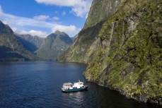 Tutoko II nudges under a waterfall during a tour exploring Doubtful Sound with Fiordland Expeditions Limited aboard the Tutoko II in Doubtful Sound, Fiordland, New Zealand. Photo: Derek Morrison