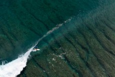 Chris "Scuzz" Scurrah skipping along the reef at a remote reefbreak in the Mentawai Islands, Sumatra, Indonesia.