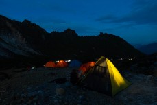Headlamps shine a trail in the pre-dawn light past campers to the summit of during a climb of Mt Sibayak (2212m) near Bergastagi, Northern Sumatra, Indonesia.
