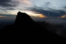Climbers take in the sunrise from one of the crater summits of Mt Sibayak (2212m) near Bergastagi, Northern Sumatra, Indonesia.