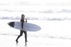 Taya Morrison heads out during a clean winter swell at Aramoana Dunedin, New Zealand.Photo: Derek Morrison
