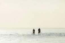 Limited Edition: Two stand up paddleboarders wait for a wave at dawn at St Clair Beach, Dunedin, New Zealand. 