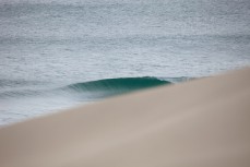 A wave breaks in Sandfly Bay, Dunedin, New Zealand. 